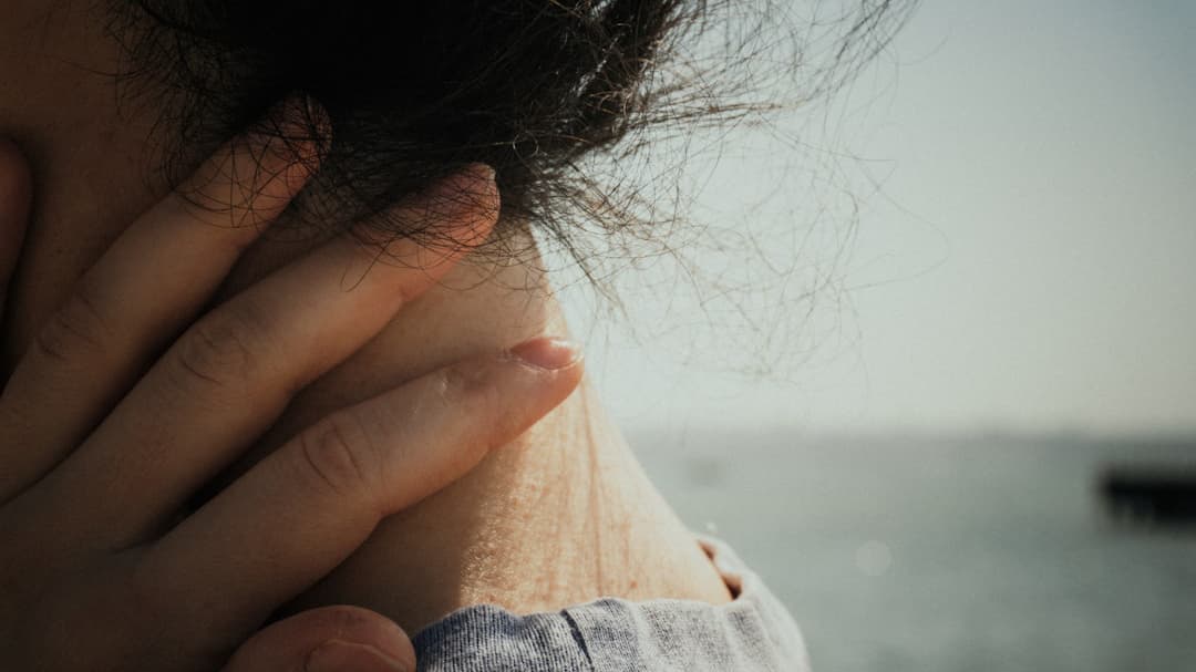 肩こりで首に手を当てる人